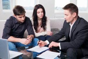 couple consults with agent, signing paperwork